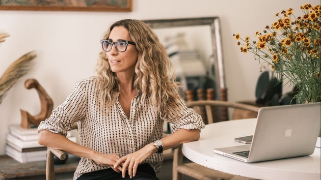 Laura Rubin of AllSwell sitting at a desk with a laptop.